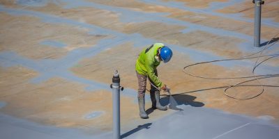 Top view male worker holding an industrial spray gun used for roof plate tank surface on steel industrial painting and coating.; Shutterstock ID 2139668259; purchase_order: -; job: -; client: -; other: -