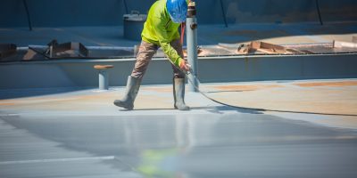 A male worker holding an industrial spray gun used for roof plate tank surface on steel industrial painting and coating.; Shutterstock ID 2253937345; purchase_order: -; job: -; client: -; other: -